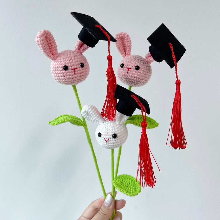 crochet cartoon character animal single stalk flower pink and white rabbit with mortarboard